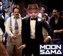 a man in a tuxedo with a pink face and a cowboy hat stands in front of a sign that says moon sama