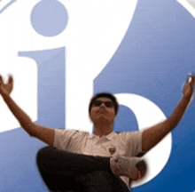 a man with his arms outstretched sitting in front of a facebook logo