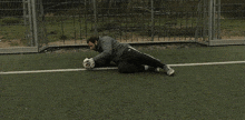 a man is kneeling down on a soccer field holding a soccer ball