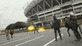 a group of people standing in a parking lot in front of a stadium with a sign that says ' tokyo ' on it