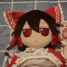 a stuffed doll with red ears and red eyes is sitting on a blanket .