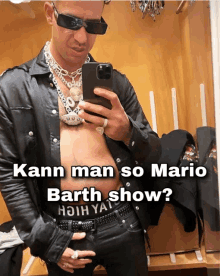 a man taking a picture of himself in a mirror with the words kann man so mario barth show below him