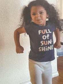 a little girl wearing a full of sun shine shirt