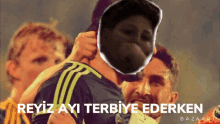 a soccer player is hugging another player with the words reyiz ayi terbiye ederken below him