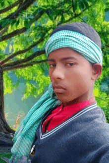 a young boy wearing a green and white head scarf