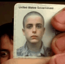 a man is holding a united states government id card