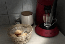 a basket of cookies sits on a counter next to a red coffee maker