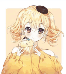 a girl in a yellow sweater is holding a cupcake