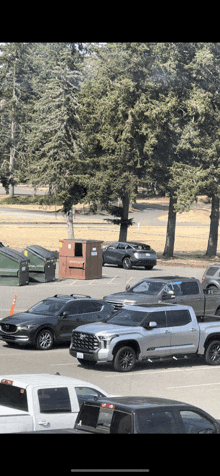 a lot of cars are parked in a parking lot including a silver truck