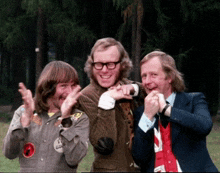 three men are posing for a picture and one of them has a badge on his jacket that says ' a ' on it