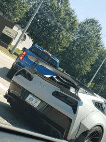 a white corvette with a license plate that says nufl uh on it