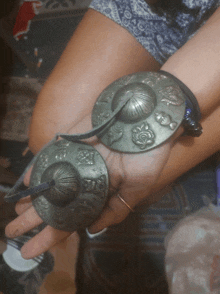 a person holding a pair of cymbals with a floral design