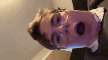 a young man with glasses is making a funny face