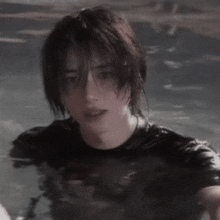 a young man in a black shirt is standing in a pool of water .