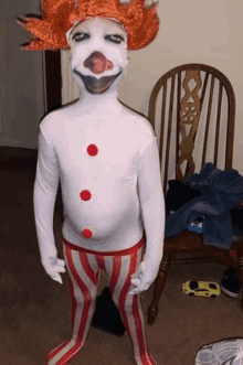 a person in a clown costume is standing next to a chair