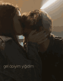 a man and a woman kissing with the words gel opiyim yiğidim written below them