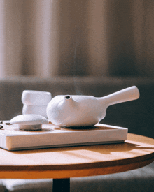 a white teapot sits on top of a white tray