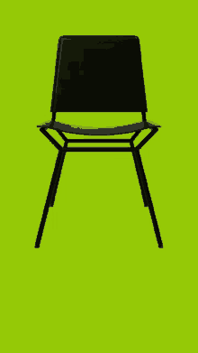 a black chair on a green background that looks like a letter a