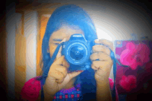 a girl is holding a canon camera in front of her face