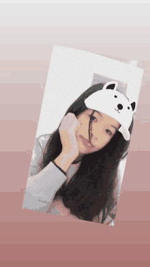 a young girl wearing a white hat with a bear on it