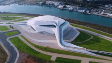 an aerial view of a large white building with a curved roof