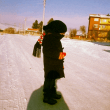 a child wearing a scarf that says ' i love you ' on it stands in the snow