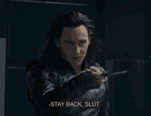 a man in a leather jacket is holding a knife and says " stay back slut "