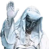 a statue of a man wearing a white robe and gloves is waving his hand