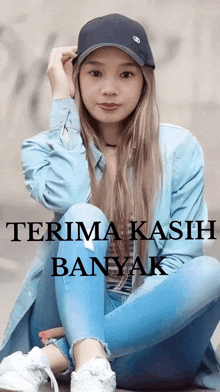 a woman wearing a hat sits on the ground with the words terima kasih banyak written below her