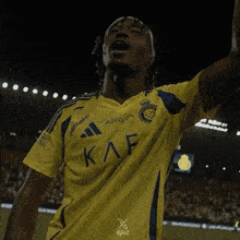 a soccer player wearing a yellow shirt with the letters kaf on it