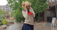 a girl in a school uniform is standing in the rain near a sign that says ' a ' on it