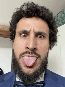 a man with a beard is sticking out his tongue