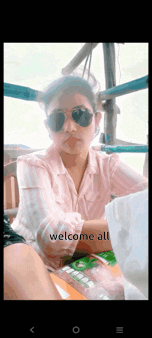 a woman wearing sunglasses is sitting at a table with the words welcome all written on the bottom