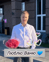 a man in a white shirt is holding a bouquet of red roses in front of a building that says ocom