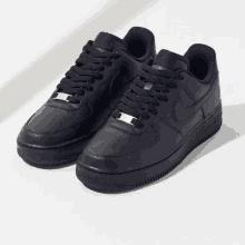 a pair of black nike air force 1 low sneakers