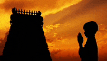 a silhouette of a person praying in front of a temple at sunset .