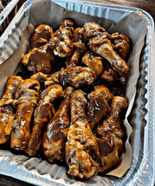 a tray filled with chicken wings and sauce