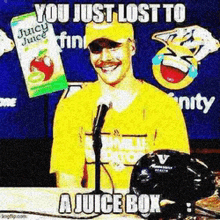 a man in a yellow shirt is standing in front of a microphone with a box of juicy juice behind him