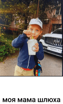 a little boy drinking from a cup with a straw in front of a car with a license plate that says 100mt61