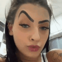 a close up of a woman 's face with a very sharp eyebrow .