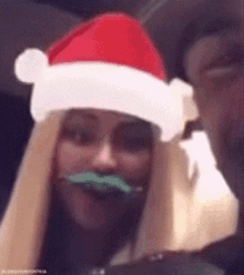 a woman is wearing a santa hat and a fake mustache