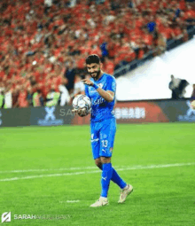 a soccer player wearing a blue jersey with the number 13 on it