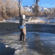 a man in a plaid shirt is fishing in a frozen river and the army logo is visible in the background