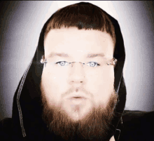 a man with a beard wearing glasses and a hood