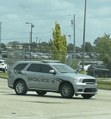 a silver police car is parked on the side of the road