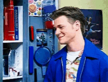 a man in a blue jacket is smiling in front of a locker that has a book titled " the smithsonian "