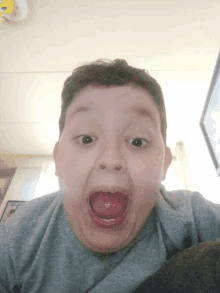 a young boy is making a funny face with his tongue out