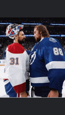 two hockey players are standing next to each other and one has the number 31 on his jersey