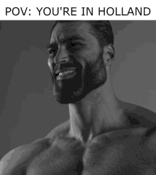 a shirtless man with a beard is smiling in a black and white photo with the caption " you 're in holland "