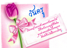 a pink flower with a pink ribbon and a card with chinese writing on it